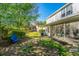 Well-maintained backyard with lush greenery, mature trees, and a blue Adirondack chair at 1002 Elm Hall Cir, Summerville, SC 29483