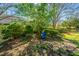 Green backyard with lush trees, a bench, and a garden bed at 1002 Elm Hall Cir, Summerville, SC 29483