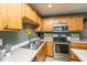 Close-up of kitchen featuring stainless steel appliances and oak cabinets at 1002 Elm Hall Cir, Summerville, SC 29483