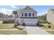 Charming two-story home with a well-maintained lawn, a palm tree, and an attached two-car garage at 101 Corvus Ct, Summerville, SC 29486