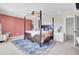 Bright main bedroom featuring a four-poster bed, colorful accent wall and a view of the ensuite bathroom at 101 Corvus Ct, Summerville, SC 29486