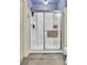 Walk-in shower featuring glass doors, white walls and silver hardware, complemented by light-colored, faux-wood flooring at 101 Corvus Ct, Summerville, SC 29486