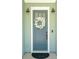 Close-up of a charming blue front door with a decorative floral wreath, and modern lighting at 1028 Harriman Ln, Charleston, SC 29492