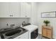 Modern laundry room with Whirlpool washer and dryer and ample white cabinet storage at 1028 Harriman Ln, Charleston, SC 29492