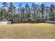 Large backyard enclosed by a wooden fence and lined with mature trees at 1144 Wading Point Blvd, Huger, SC 29450
