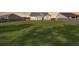 Large, sprawling backyard with green grass and a view of the home's rear facade at 1144 Wading Point Blvd, Huger, SC 29450