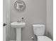 Elegant half-bathroom featuring a pedestal sink, ornate mirror and modern fixtures at 1144 Wading Point Blvd, Huger, SC 29450