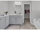Bright bathroom with a double vanity, bathtub, walk-in closet, and linen closet at 1144 Wading Point Blvd, Huger, SC 29450