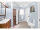 Well-lit bathroom with a shower, vanity, white toilet, and light blue walls and neutral tile flooring at 1162 South Shadow Dr, Mount Pleasant, SC 29464