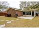 Exterior view of a brick home with a sunroom and backyard patio at 1162 South Shadow Dr, Mount Pleasant, SC 29464