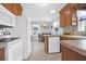 Well-lit kitchen with wooden cabinetry, tile countertops, and a dining area with natural light from the window at 1162 South Shadow Dr, Mount Pleasant, SC 29464