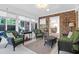 Cozy sunroom with comfortable wicker furniture, brick wall accent, and ample natural light from the large windows at 1162 South Shadow Dr, Mount Pleasant, SC 29464