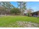 Expansive backyard featuring lush green grass, mature trees, and a covered storage area at 117 Hartin Blvd, Summerville, SC 29486
