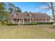 Charming brick home featuring dormer windows, manicured landscaping, and a welcoming front porch at 117 Hartin Blvd, Summerville, SC 29486