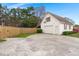 Detached garage with white siding, red shutters, and a large concrete driveway at 117 Hartin Blvd, Summerville, SC 29486