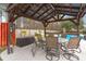 Outdoor dining area beneath a pergola, equipped with ceiling fans, and poolside seating for relaxation and enjoyment at 117 Hartin Blvd, Summerville, SC 29486