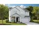 Charming two-story home featuring a two-car garage, welcoming front porch, and light green siding at 118 Moscato Ln, Summerville, SC 29485