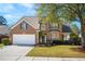Charming two-story brick home with a well-manicured front yard and attached two-car garage in a desirable neighborhood at 123 Thousand Oaks Ct, Summerville, SC 29485