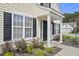 Home entrance featuring a dark front door, white columns, and landscaping at 1249 Shadow Mist Ln, Charleston, SC 29492