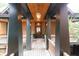 Inviting entrance with wood decking, dark wood columns, a charming light fixture, and a view of the front door at 127 Blue Heron Pond Rd # A, Kiawah Island, SC 29455