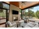 Cozy screened-in outdoor living space features a stone fireplace and views of the pool and landscape at 127 Blue Heron Pond Rd # A, Kiawah Island, SC 29455