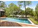 Gorgeous pool with sun deck overlooks water feature surrounded by lush greenery and a wooden deck at 127 Blue Heron Pond Rd # A, Kiawah Island, SC 29455