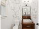 Stylish powder room featuring floral wallpaper, a marble sink, and modern lighting at 127 Blue Heron Pond Rd # A, Kiawah Island, SC 29455
