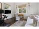 Bright home office with a desk, sofa, peloton bike and two windows offering natural light at 127 Blue Heron Pond Rd # B, Kiawah Island, SC 29455