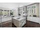 Bright kitchen featuring an island with a marble countertop, stainless steel appliances, and a modern light fixture at 127 Blue Heron Pond Rd # B, Kiawah Island, SC 29455