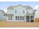 Rear view of home showcasing screened porch and ample windows for natural light at 1420 Homecoming Blvd, Ravenel, SC 29470