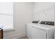 Bright laundry room features modern appliances and minimalist design at 1420 Homecoming Blvd, Ravenel, SC 29470