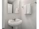 Clean, minimalist bathroom with a pedestal sink, chrome fixtures, and fresh white towels on display at 1457 Red Tide Rd, Mount Pleasant, SC 29466