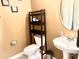 Cozy powder room featuring a pedestal sink and a toilet, complemented by a small storage shelf and neutral paint at 148 Saint Charles Way, Goose Creek, SC 29445