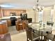 Open-concept kitchen features dark brown cabinets and black appliances, with a dining table set near the kitchen island at 148 Saint Charles Way, Goose Creek, SC 29445