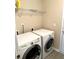 Functional laundry area with a white washer and dryer set against a light beige wall with overhead shelving at 148 Saint Charles Way, Goose Creek, SC 29445