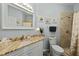 Well-lit bathroom with a vanity featuring a granite countertop, toilet, and tiled shower, offering both style and function at 1522 Telfair Way, Charleston, SC 29412