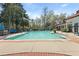 Large community pool surrounded by lounge chairs, umbrellas, and mature trees, perfect for summer relaxation at 1522 Telfair Way, Charleston, SC 29412
