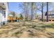 Spacious backyard with mature trees, a deck with an umbrella, offering ample room for recreation and outdoor activities at 1704 Tolbert Way, Mount Pleasant, SC 29466