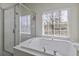 Soaking tub situated next to a window and a shower in this bright and airy bathroom at 1704 Tolbert Way, Mount Pleasant, SC 29466