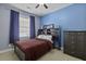Cozy bedroom with a dark wooden dresser, a comfortable bed, and blue walls with plenty of light at 1704 Tolbert Way, Mount Pleasant, SC 29466