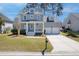 Charming two-story home boasts a welcoming front porch, manicured lawn, and two-car garage at 1704 Tolbert Way, Mount Pleasant, SC 29466