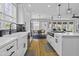 A gourmet kitchen boasts sleek white cabinets, modern appliances, and a view to the adjacent dining area at 1704 Tolbert Way, Mount Pleasant, SC 29466