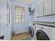 The laundry room features modern washer and dryer units, storage cabinets and a window at 1704 Tolbert Way, Mount Pleasant, SC 29466