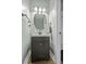 A charming powder room with a modern vanity, round mirror, and decorative lighting at 1704 Tolbert Way, Mount Pleasant, SC 29466