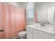 Bright bathroom featuring a single sink vanity, large mirror, and a pink waffle-weave shower curtain for a fresh aesthetic at 1772 Agate Bay Dr, Mount Pleasant, SC 29466