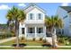 Charming two-story white home with a welcoming front porch and lush landscaping with palm trees in a quiet neighborhood at 1772 Agate Bay Dr, Mount Pleasant, SC 29466