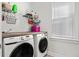 Well-lit laundry room with modern Samsung washer and dryer, butcher block countertop, and wire shelving for efficient storage at 1772 Agate Bay Dr, Mount Pleasant, SC 29466