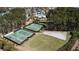 Aerial view of two tennis courts and a horse ring surrounded by green trees and grass at 1772 Agate Bay Dr, Mount Pleasant, SC 29466