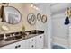 A stylish bathroom with double sinks, floral wallpaper, and a combined tub and shower at 185 5Th Ave, Mount Pleasant, SC 29464