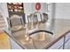 Close-up of kitchen island featuring dark granite countertop and a stainless steel sink with fixtures at 185 5Th Ave, Mount Pleasant, SC 29464